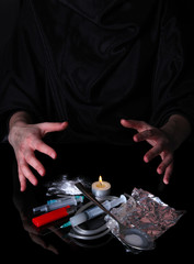 Drug addict with syringe on black background