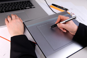 Female hand using graphics tablet on table close up