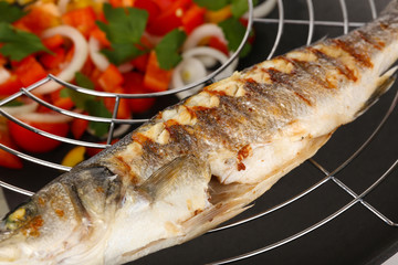 Delicious grilled fish on wok close-up