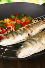 Delicious grilled fish on wok close-up