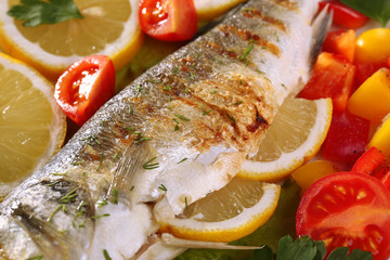 Delicious grilled fish on plate on table close-up