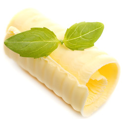 Curl of fresh butter with basil, isolated on white