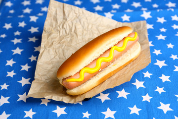 Tasty hot dog on napkin with stars, isolated on white
