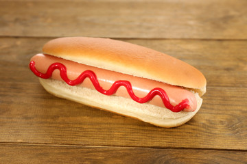 Tasty hot dog on wooden table