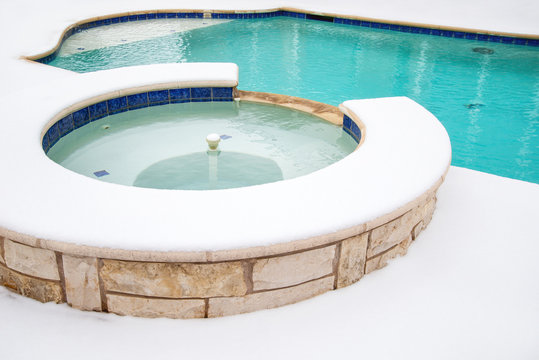 Outdoor hot tub or spa by swimming pool in the winter