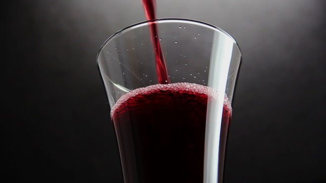 Cherry juice in glass on black background