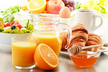 Breakfast with coffee, orange juice, croissant, egg, vegetables