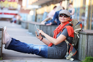 Fototapeta premium Young woman in town using electronic tablet