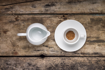 Instant coffee in empty cup with empty milk jag