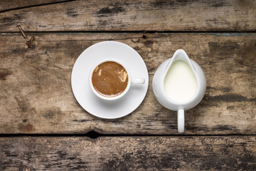 Cup of Coffee with Milk Jug on Wood Background.  Top View