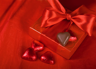 Gift and sweets heart on a red background