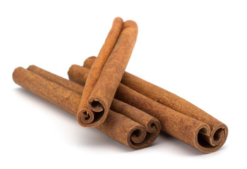 cinnamon sticks stacked on white background
