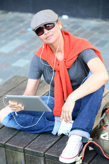 Fototapeta premium Beautiful young woman listening music in urban landscape