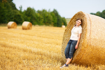Naklejka na ściany i meble Young beautiful woman on yellow golden hay field, Germany