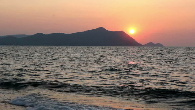 Nice sunset on the beach behide high moutain
