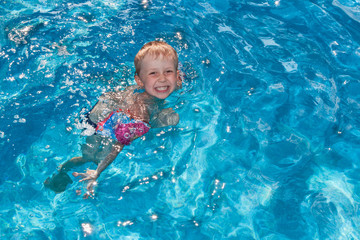 Fototapeta na wymiar Boy swims in the pool