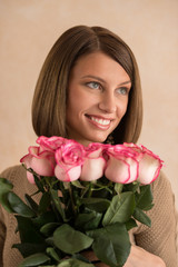 Pretty brunette woman holding bunch of roses