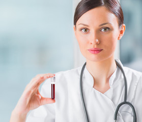 Portrait of pretty female laboratory assistant analyzing a blood
