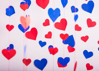 Background of red and blue paper hearts hanging on strings