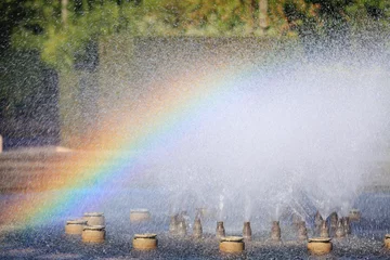 Papier Peint photo Fontaine Splashing water of a fountain with rainbow