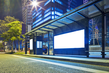 Blank billboard on bus stop at night