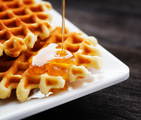 Honey pouring on a fresh waffles