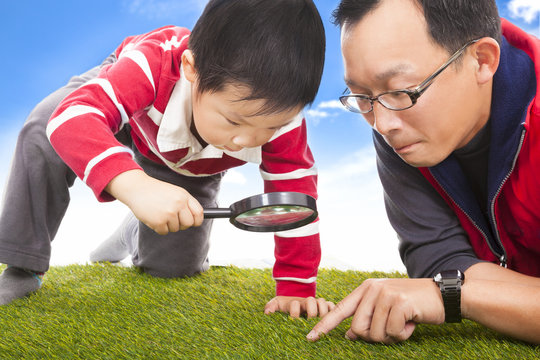 Father And Kid With Magnifying Glass To Discover