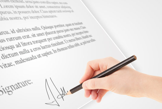 Hand writing personal signature on a paper form