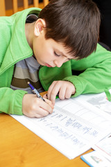 Naklejka premium bored and tired boy doing homework