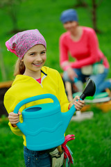 Gardening - girl helping mother in the garden