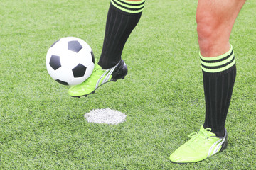 soccer ball with foot of player kicking it