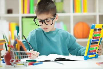  Little boy with glasess at home studying