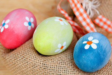 Easter eggs decorated with daisies and a sack