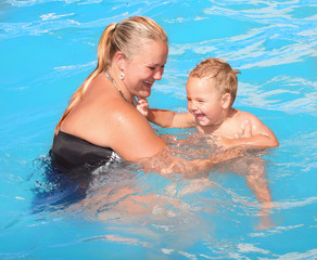 Young mother with her baby boy in the swimming pool.
