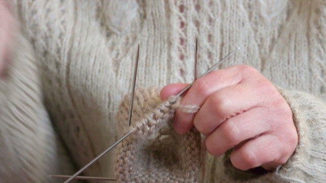 closeup of female hands knitting wool socks