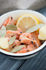 Enameled bowl with boiled king shrimps, close-up