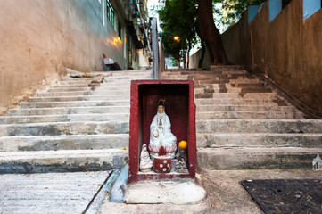 Fototapeta na wymiar Hong Kong street shrine containing statue of Guanyin