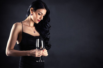 beautiful woman in a black dress with a glass in hand