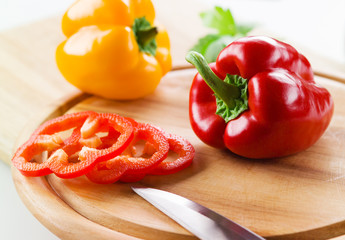 Organic paprika peppers with slice over wooden table