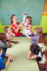 Kinder spielen mit Regenmacher im Kindergarten