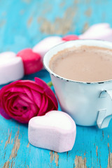 hot chocolate and heart-shaped marshmallow on wooden surface