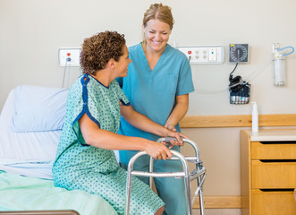 Nurse Assisting Patient Using Walking Frame In Hospital