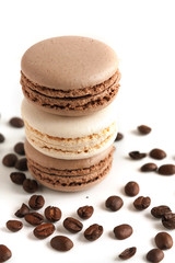 Макаруны и кофейные зерна на белом фоне