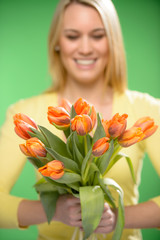 Orange spring tulips woman in background