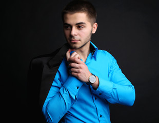 Handsome young man in suit on dark background
