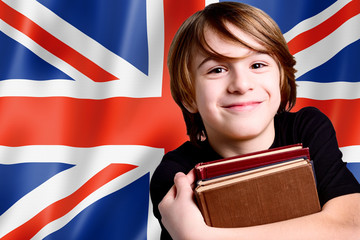 smiling little boy on uk flag with books - learn english language