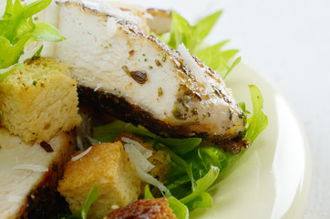 Caesar chicken salad on white table