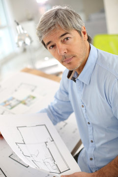 Architect working on blueprint in office