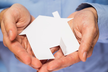Man holding paper house in his hands