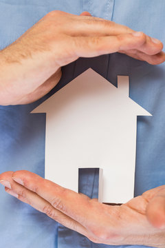 Man holding paper house in his hands